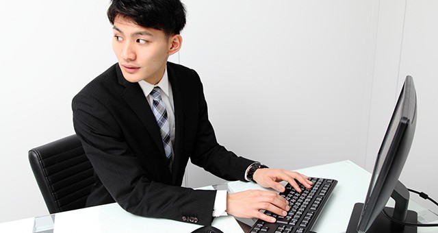 パソコン操作中に振り返る男性