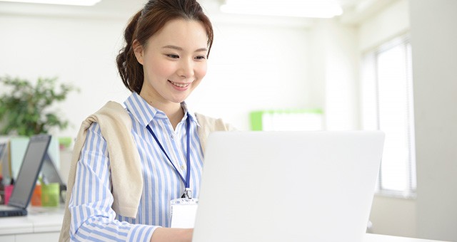 パソコンを見ながら微笑む女性