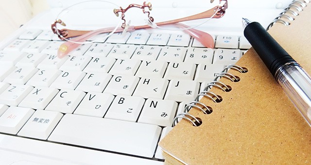 眼鏡とメモ帳とキーボード