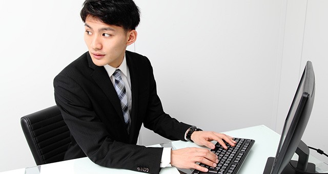 パソコンを操作中に振り返る男性